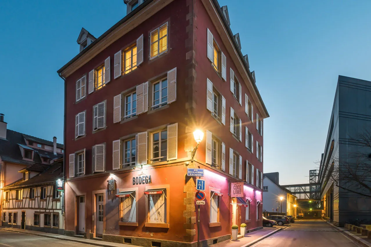 La façade rouge du Cocolobo à la tombée de la nuit, rue des Glacières